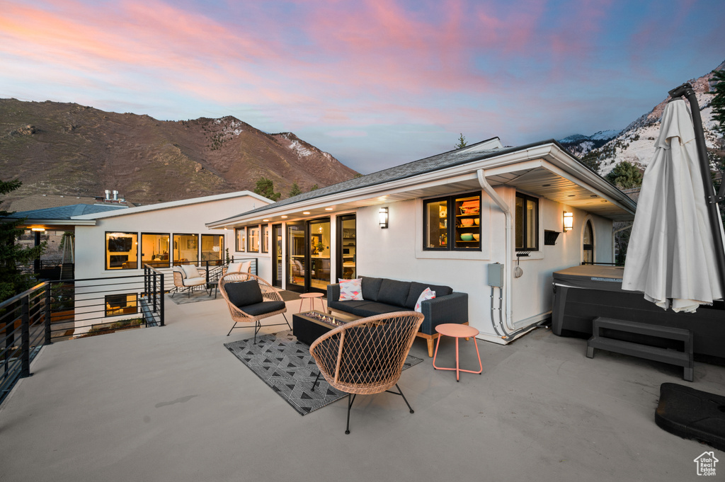Exterior space featuring an outdoor hangout area, a mountain view, and a hot tub