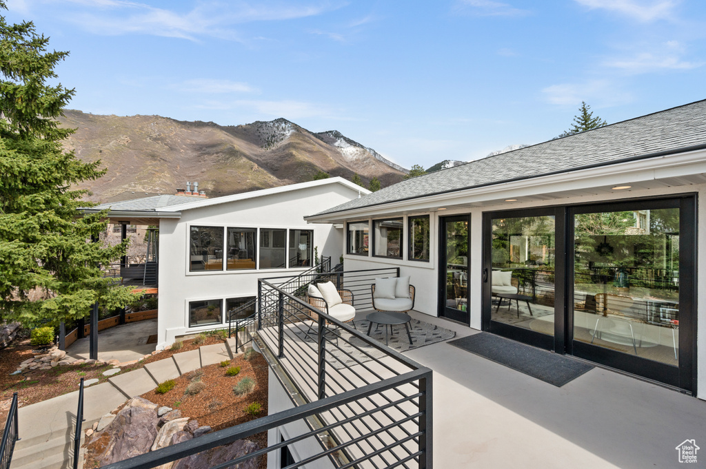 Exterior space with a sunroom, a mountain view, and a patio