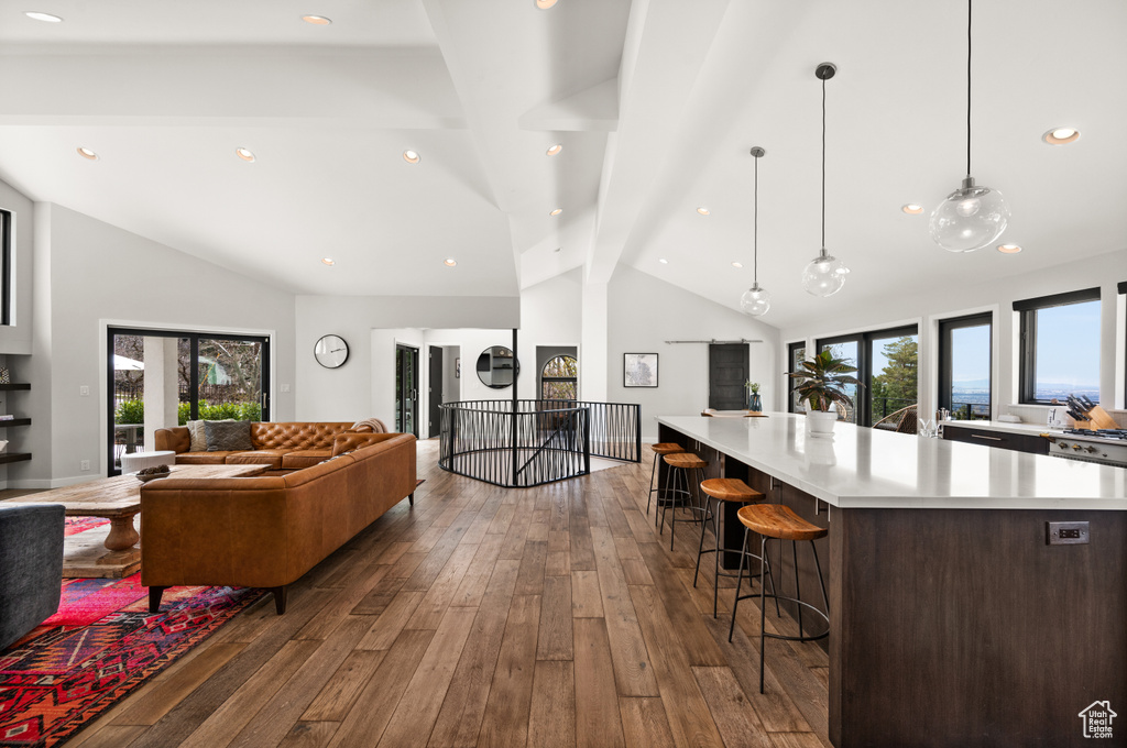 Living room with high vaulted ceiling, dark hardwood / wood-style floors, and beam ceiling