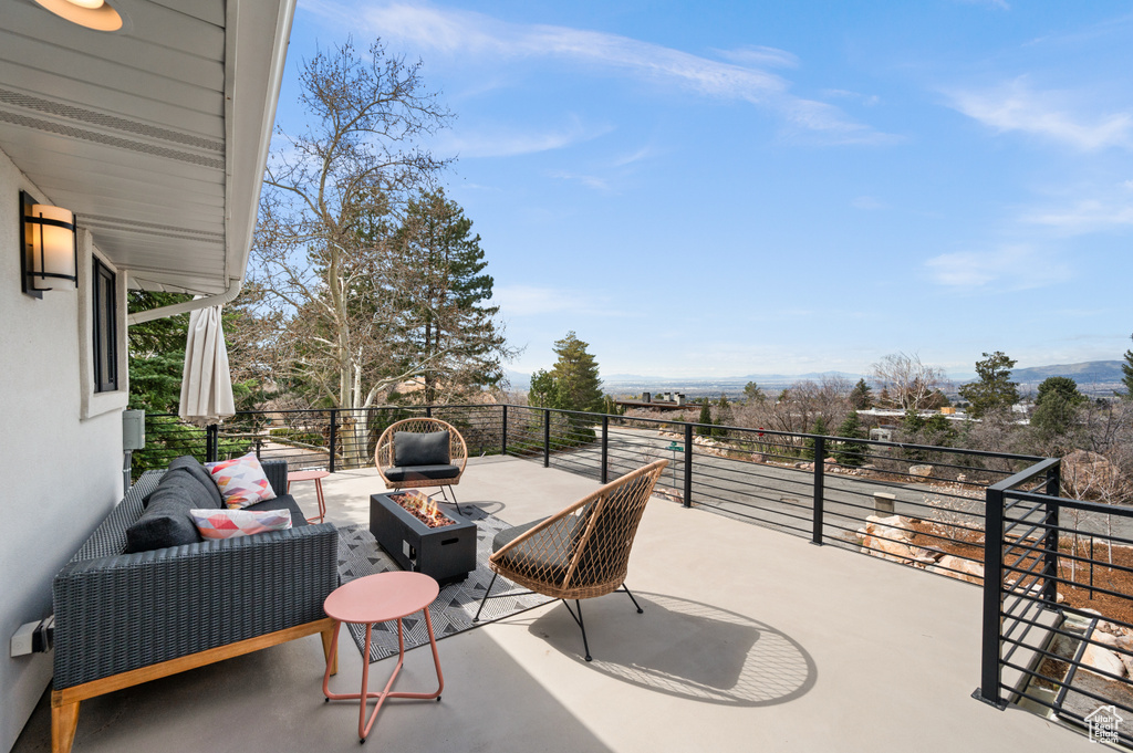 View of terrace featuring a balcony and an outdoor living space with a fire pit