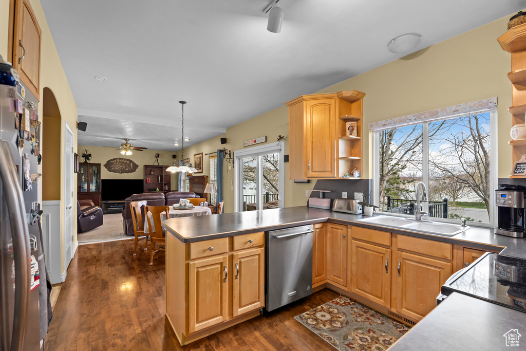 Kitchen with stainless steel appliances, dark wood-type flooring, kitchen peninsula, sink, and ceiling fan