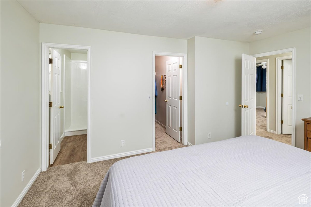 Bedroom with light carpet and a spacious closet