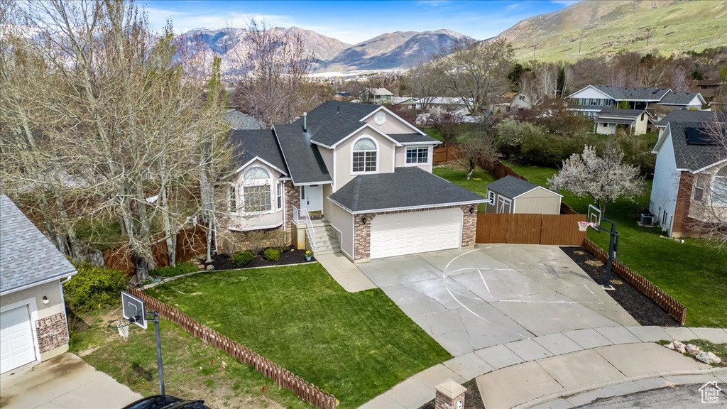 View of front property with a front yard, a mountain view, and a garage