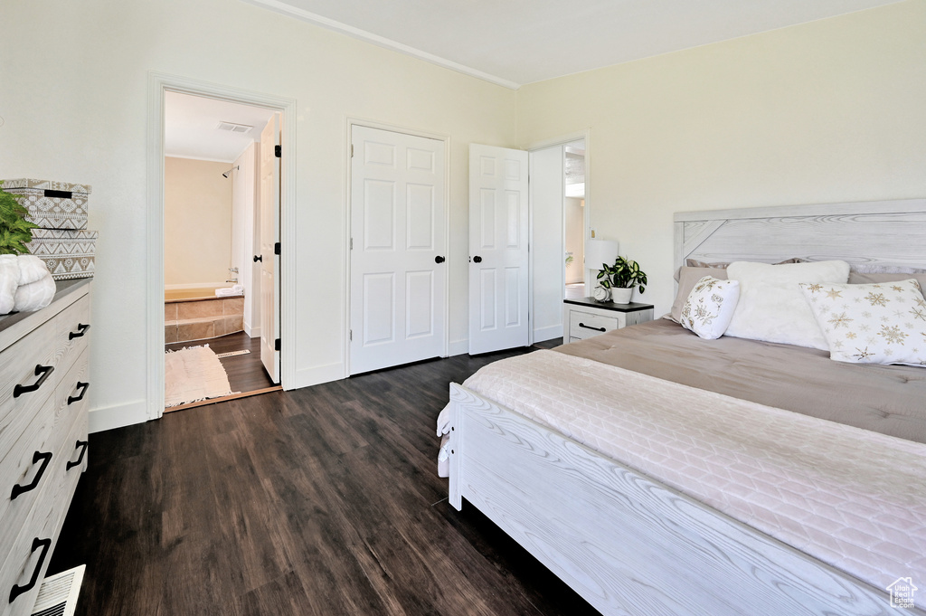 Bedroom with dark hardwood / wood-style flooring and ensuite bath