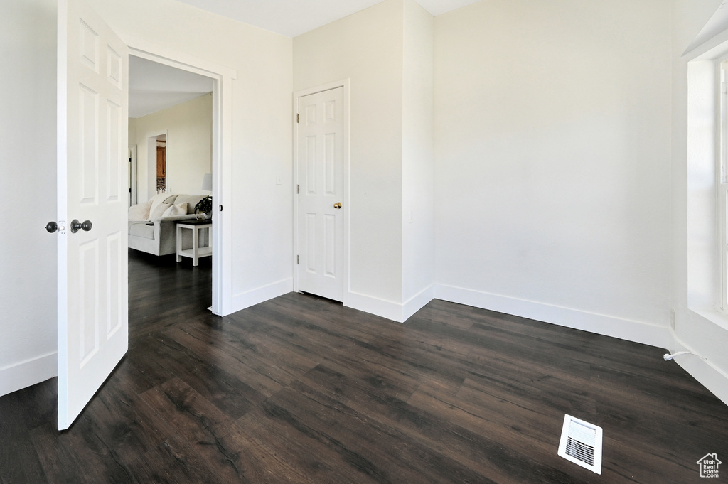 Empty room with dark hardwood / wood-style flooring