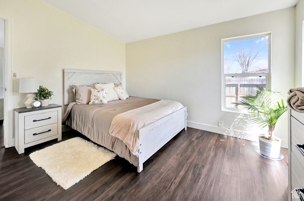 Bedroom featuring multiple windows and dark hardwood / wood-style floors