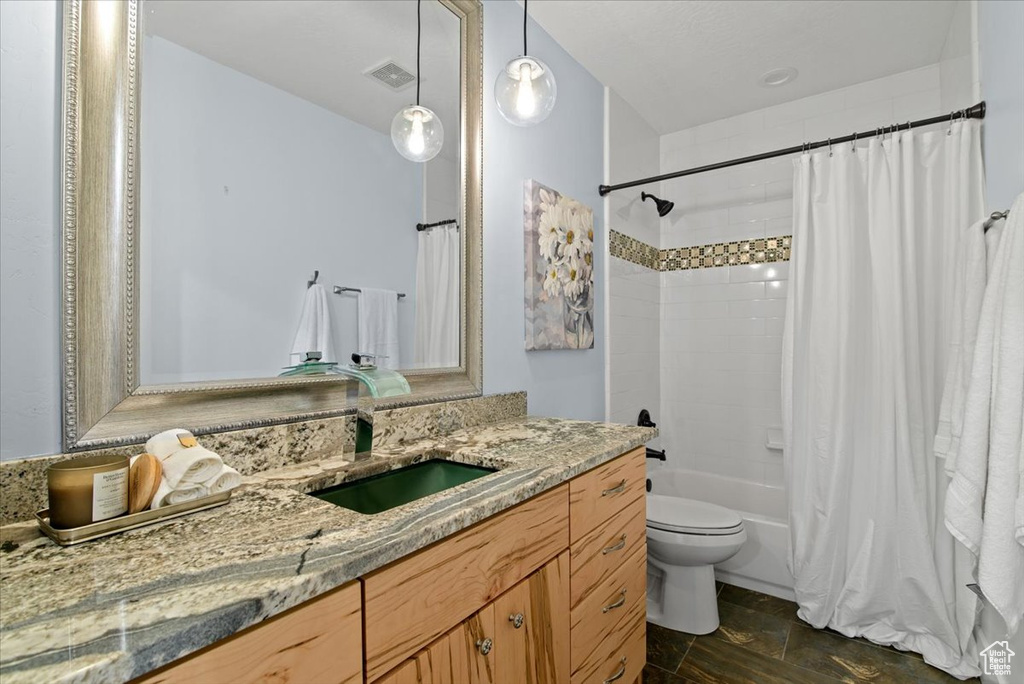 Full bathroom with tile floors, toilet, shower / bath combo, and vanity
