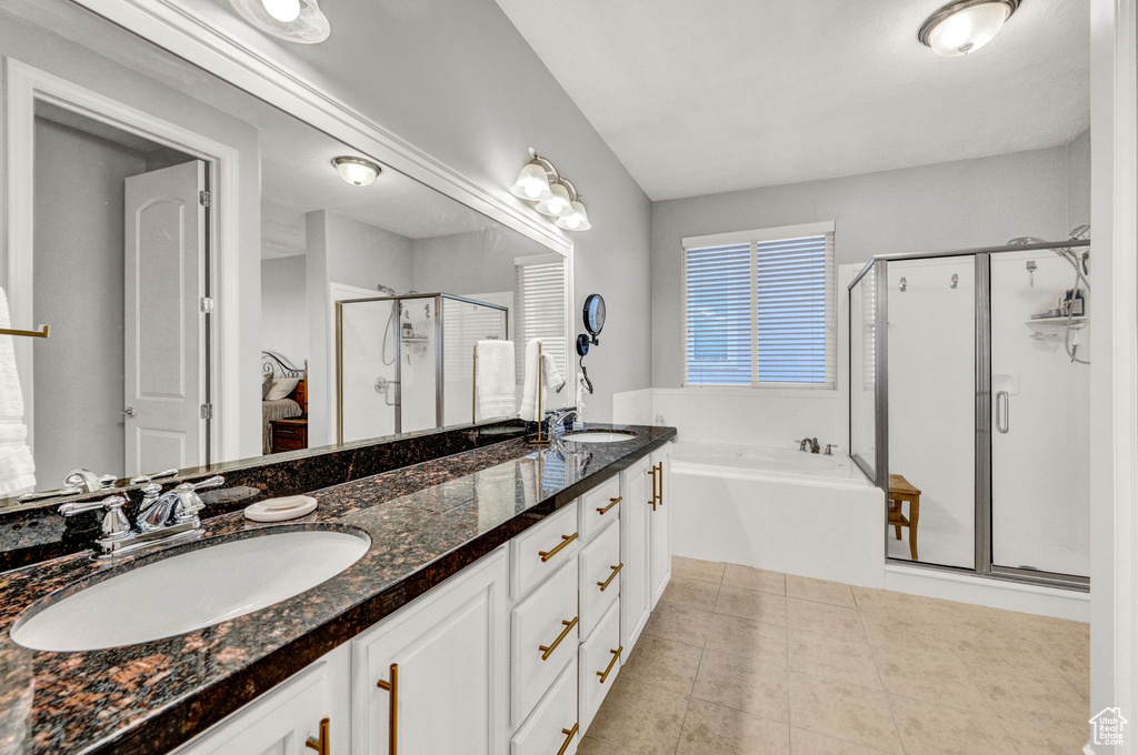 Bathroom with tile floors, independent shower and bath, and double sink vanity