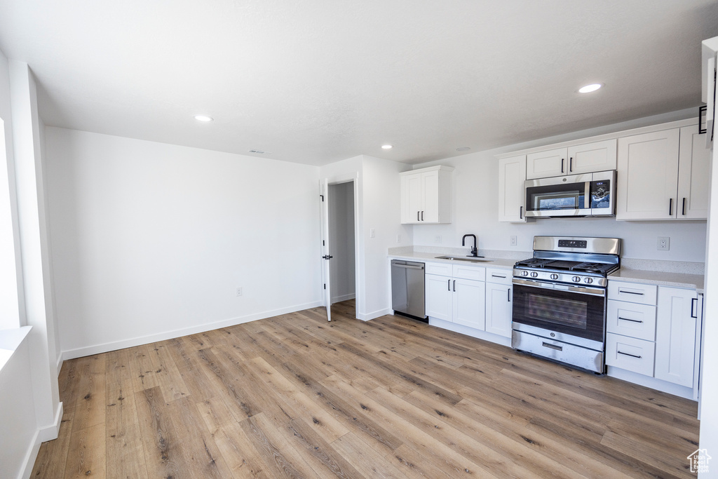 Kitchen featuring white cabinetry, light hardwood / wood-style flooring, and stainless steel appliances