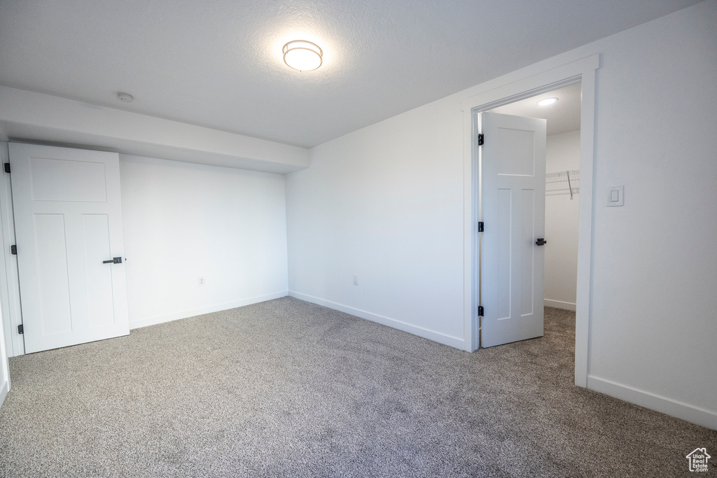 Interior space with a closet, a walk in closet, and carpet floors