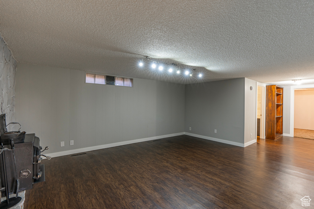 Interior space with track lighting, dark hardwood / wood-style floors, and a textured ceiling