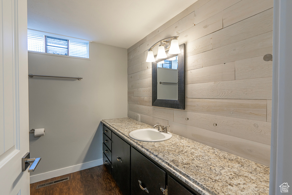 Bathroom with wood walls, wood-type flooring, and vanity