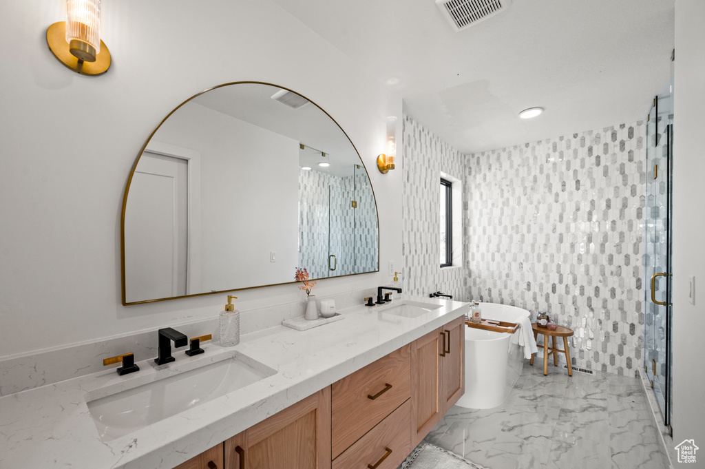 Bathroom featuring tile floors, tile walls, dual vanity, and walk in shower