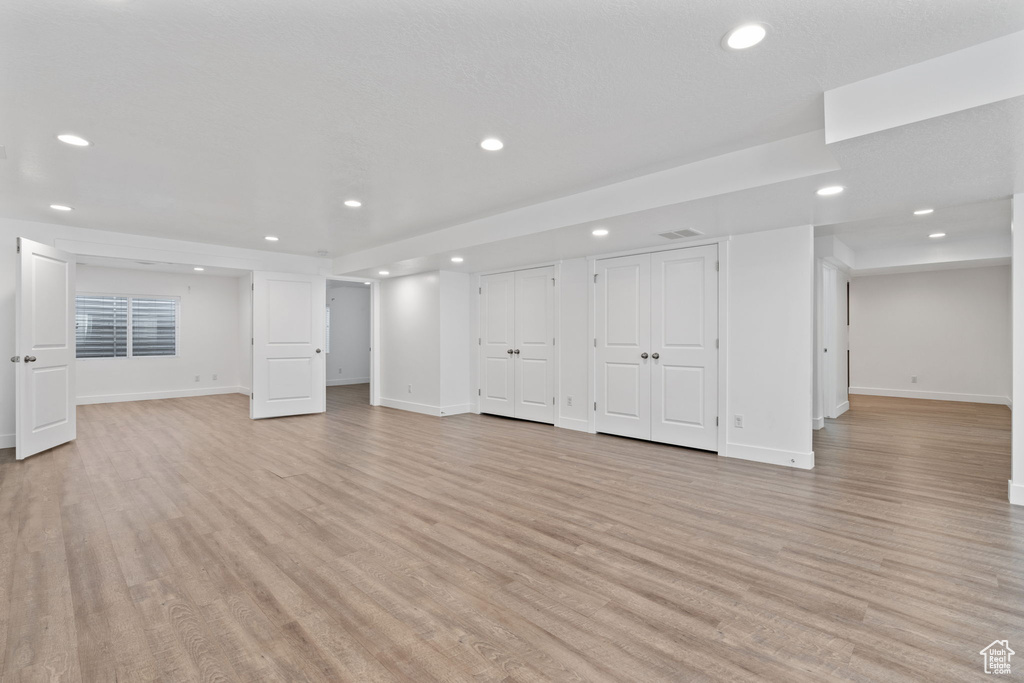 Basement with light hardwood / wood-style floors