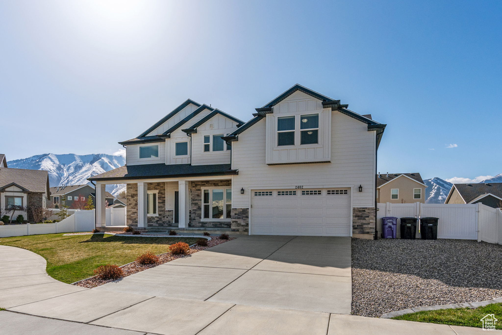 Craftsman-style home with covered porch, a garage, and a mountain view