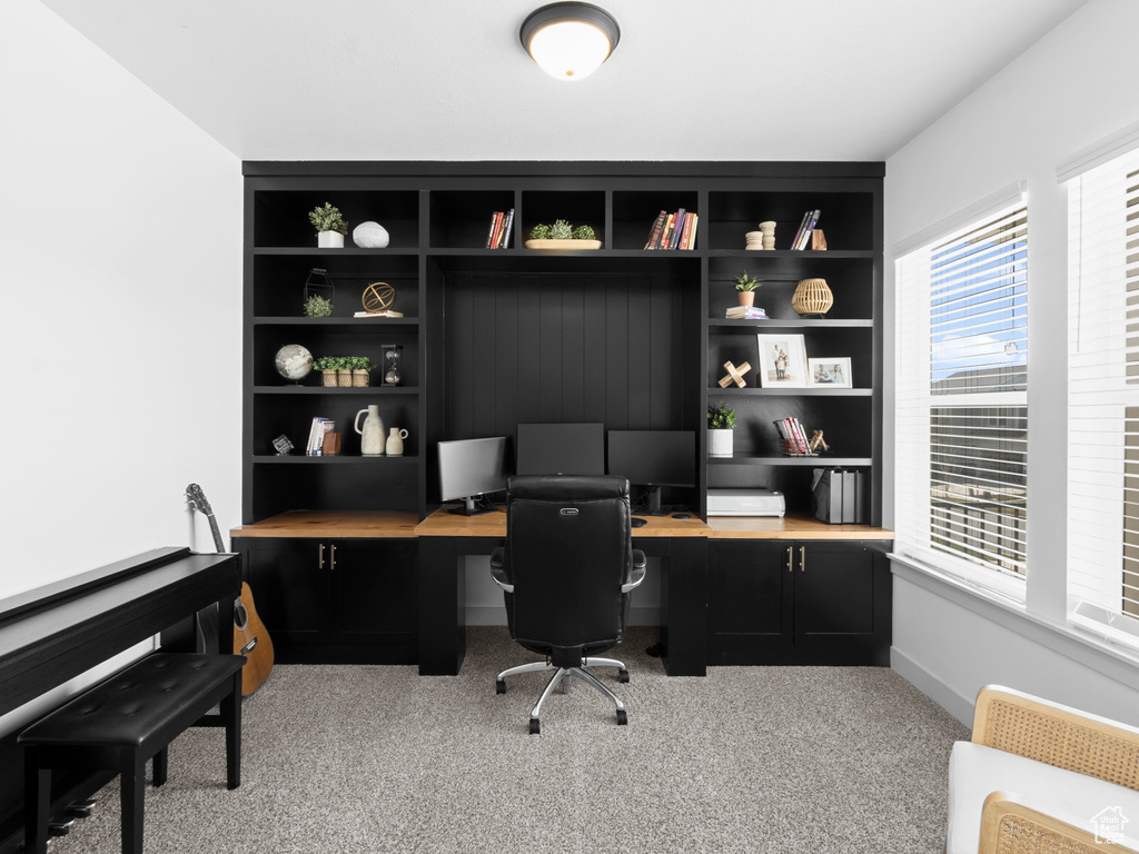 Carpeted office featuring built in desk