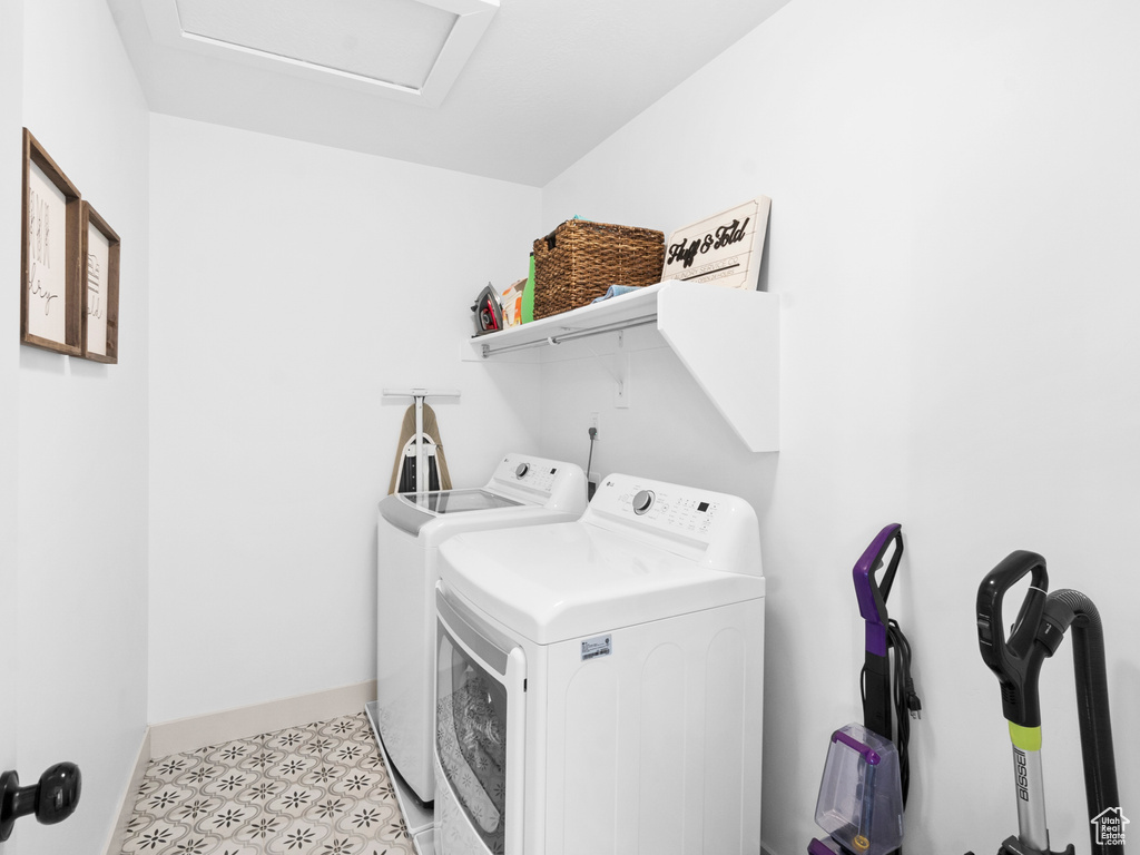 Laundry room with washing machine and dryer and light tile floors