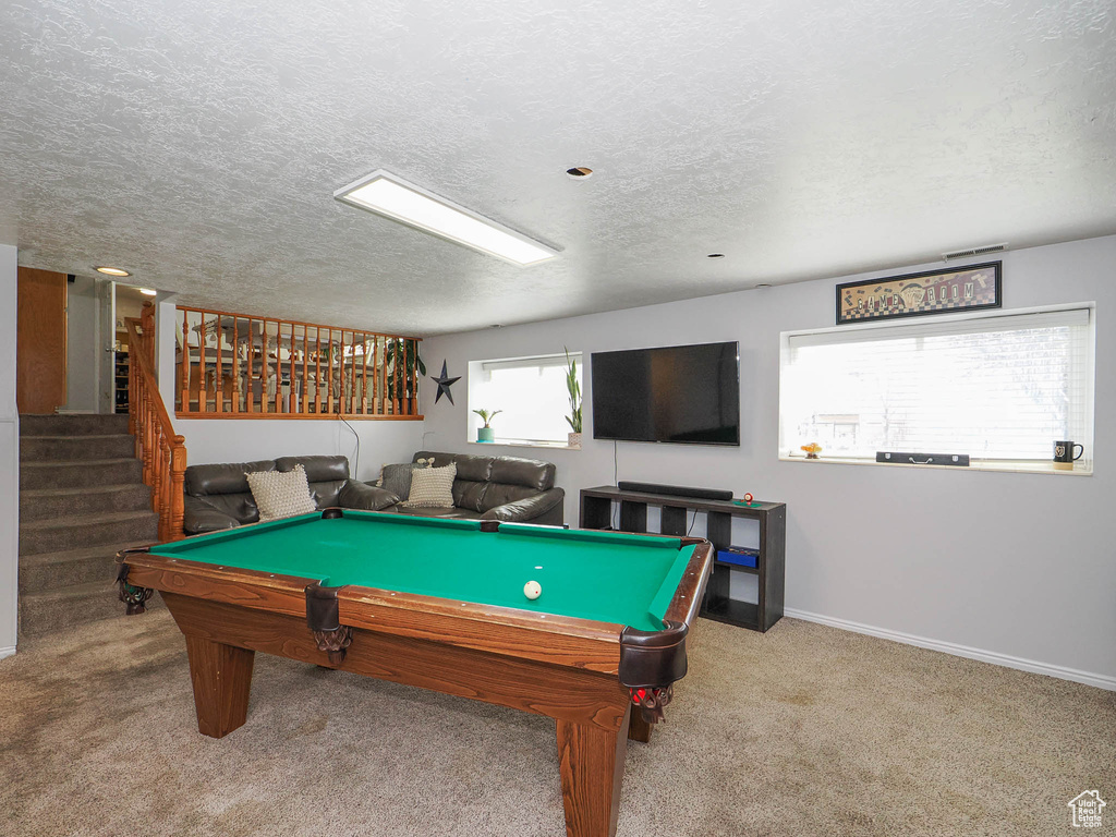 Playroom with billiards, a textured ceiling, and light carpet