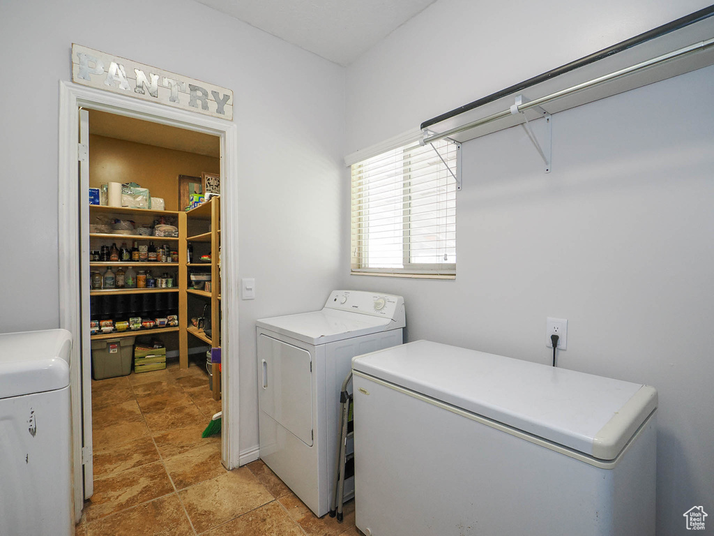 Laundry room with washer and dryer and light tile floors
