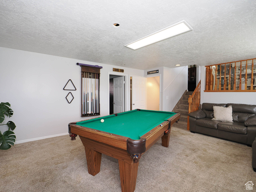 Recreation room featuring billiards, a textured ceiling, and light carpet