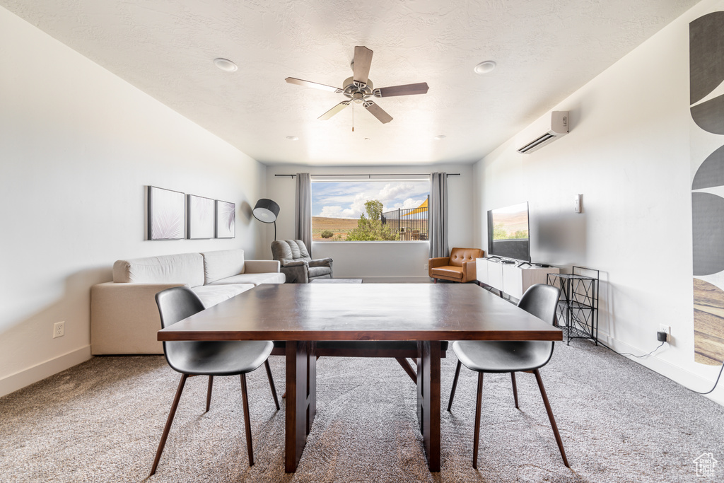 Carpeted dining area featuring an AC wall unit and ceiling fan
