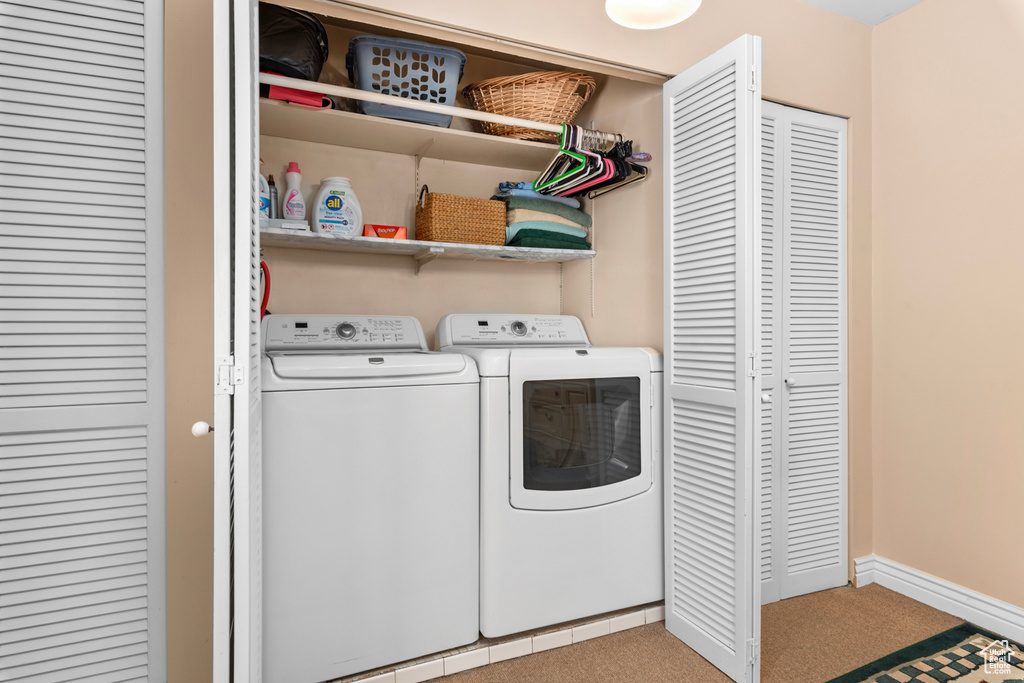 Laundry area with light carpet and washer and dryer