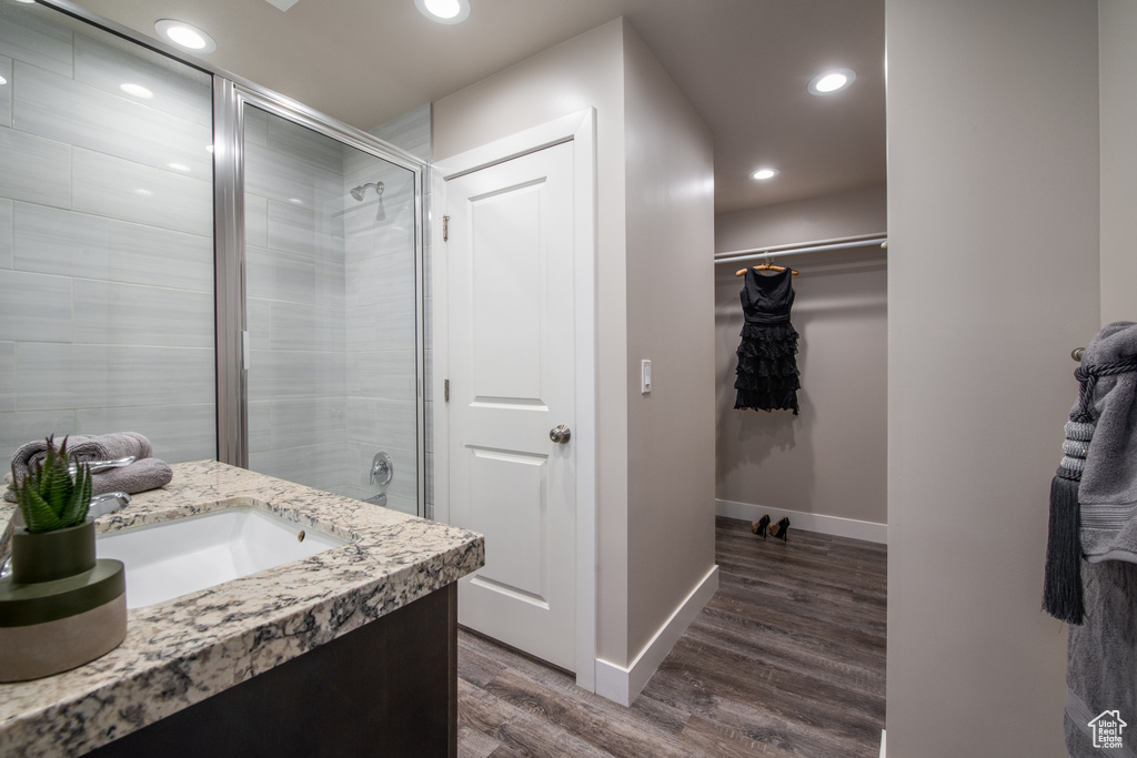 Bathroom with hardwood / wood-style floors, walk in shower, and vanity