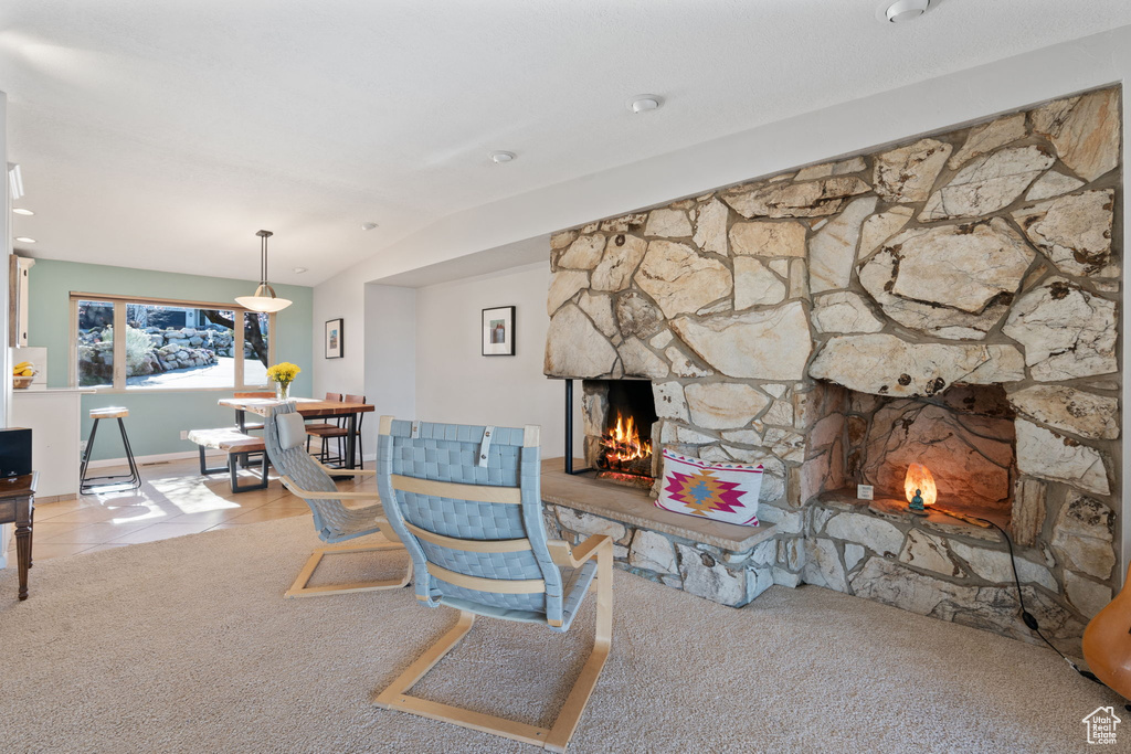 Living room featuring light colored carpet and a stone fireplace