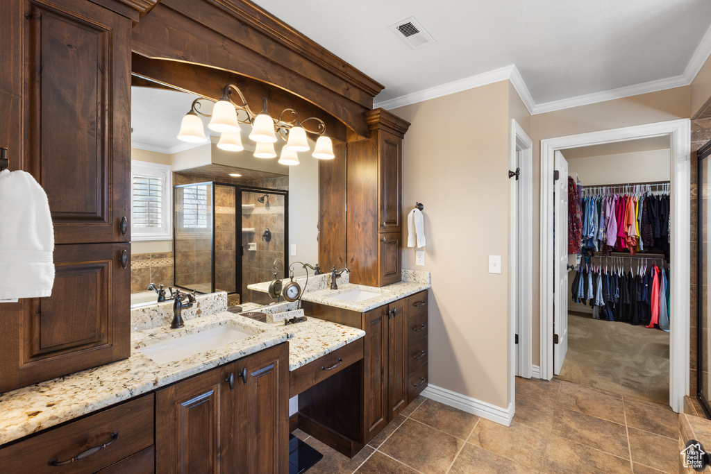 Bathroom with crown molding, tile floors, a shower with shower door, and dual bowl vanity