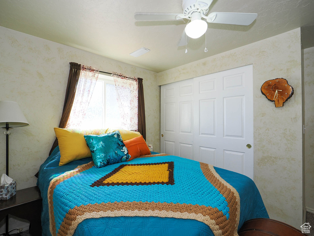 Bedroom featuring ceiling fan and a closet