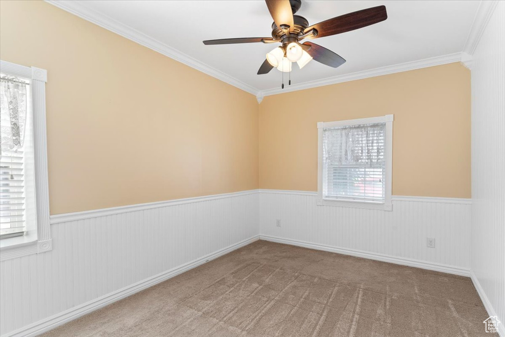 Unfurnished room featuring ornamental molding, light colored carpet, and ceiling fan