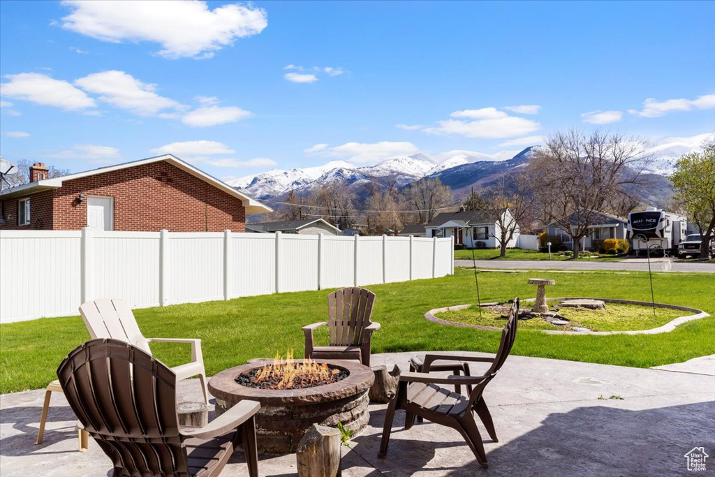 View of patio / terrace featuring an outdoor fire pit and a mountain view