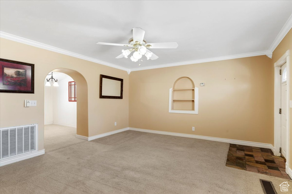 Carpeted spare room with ceiling fan and ornamental molding