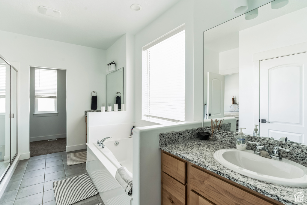 Bathroom featuring tile flooring, plus walk in shower, and vanity
