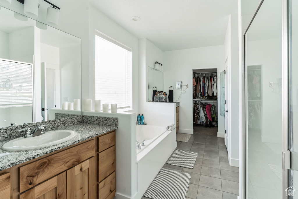 Bathroom with tile flooring, separate shower and tub, and vanity with extensive cabinet space