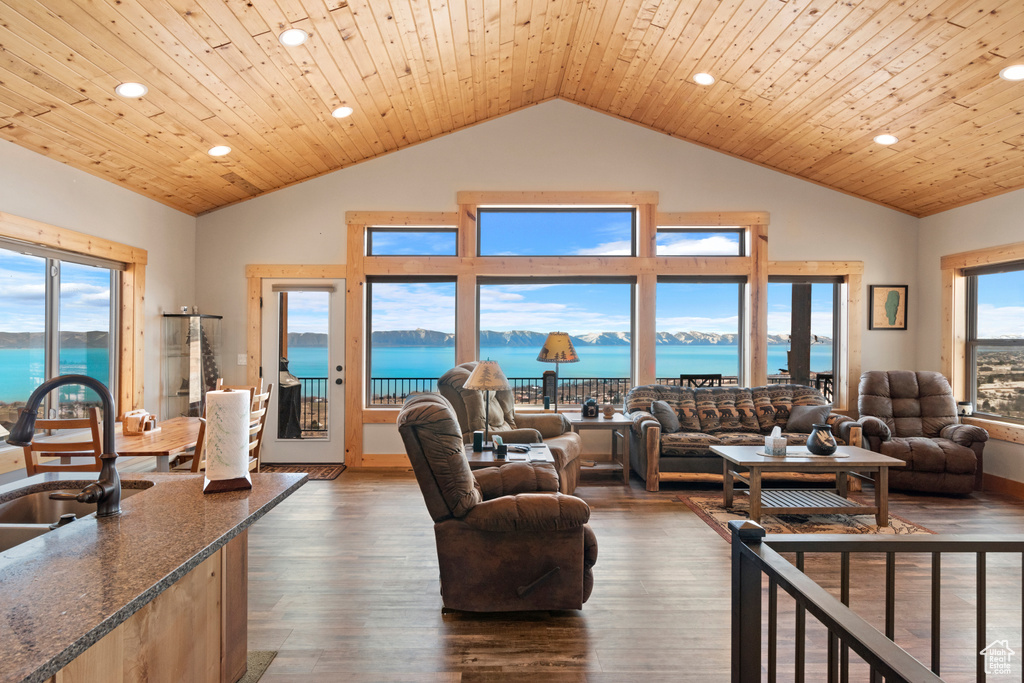 Living room with a water view, wood ceiling, dark hardwood / wood-style floors, and a wealth of natural light