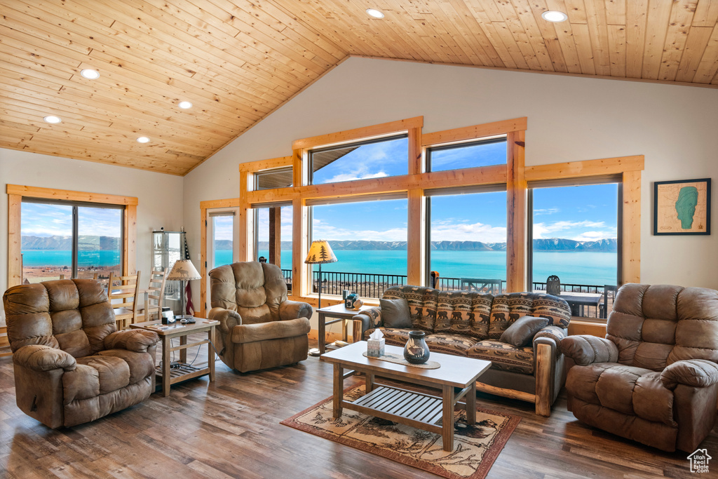 Living room with a water view, dark hardwood / wood-style floors, wood ceiling, and a wealth of natural light