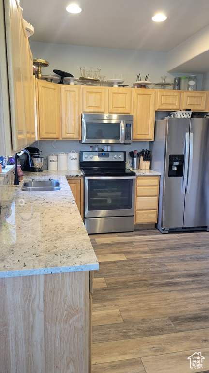 Kitchen featuring appliances with stainless steel finishes, hardwood / wood-style floors, light brown cabinets, and sink