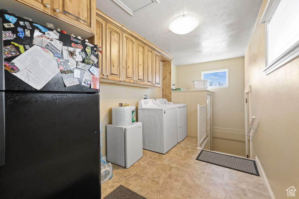 Laundry room with independent washer and dryer, cabinets, and light tile flooring