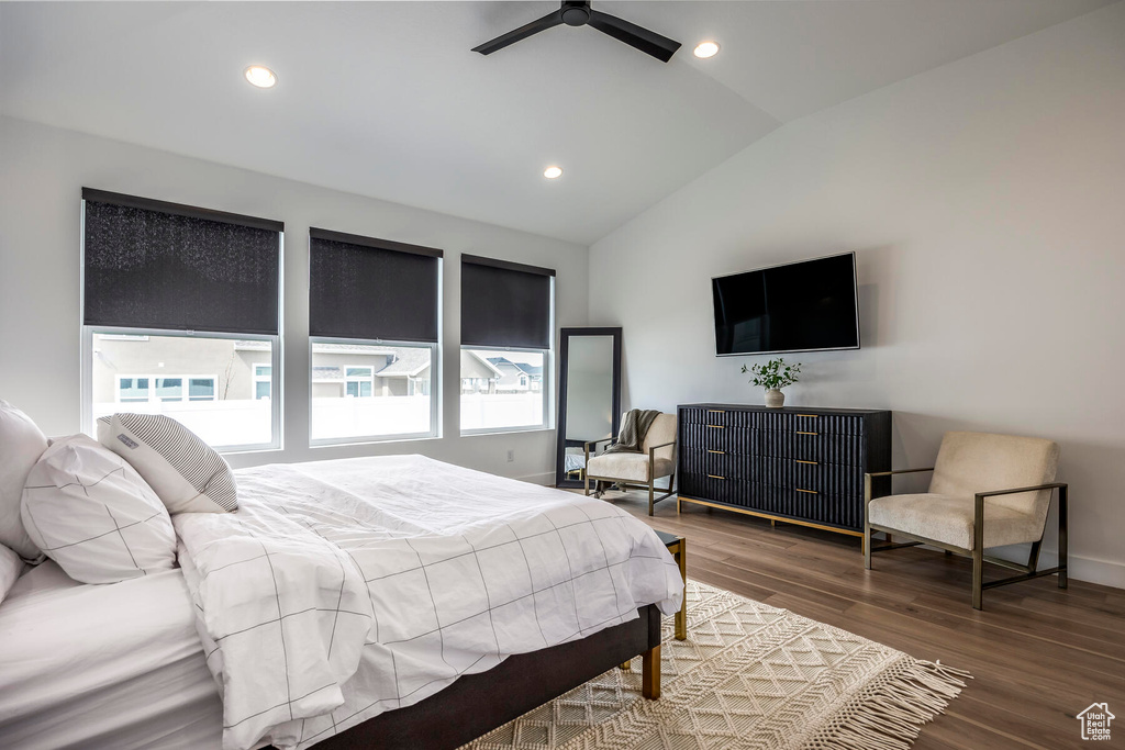 Bedroom featuring dark hardwood / wood-style flooring, ceiling fan, lofted ceiling, and multiple windows