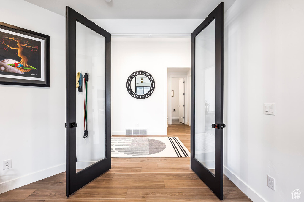 Hall featuring light hardwood / wood-style floors and french doors