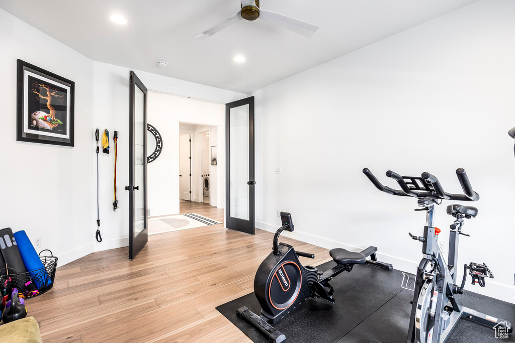 Exercise area with ceiling fan, light wood-type flooring, and french doors
