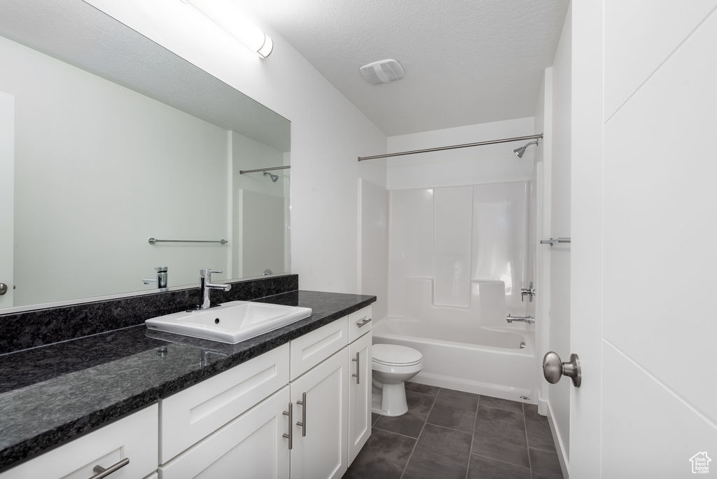 Full bathroom featuring tub / shower combination, tile flooring, a textured ceiling, toilet, and vanity
