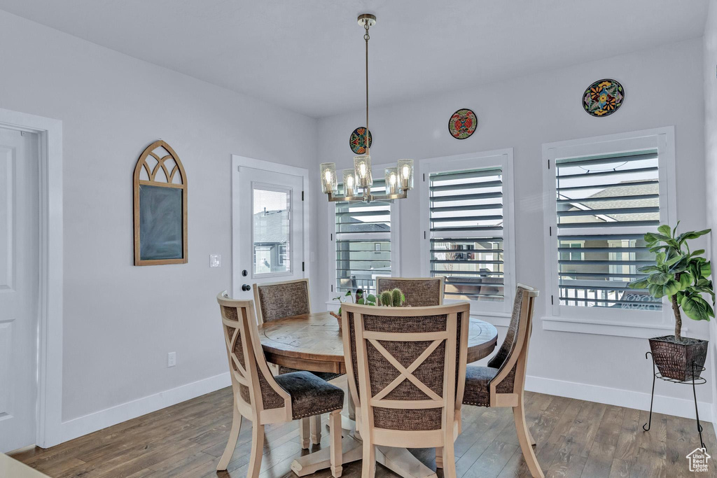 Dining area featuring a notable chandelier, dark wood-type flooring, and plenty of natural light
