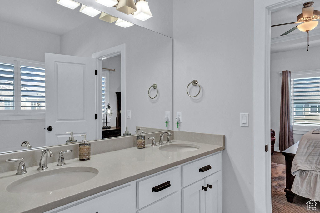 Bathroom with ceiling fan, plenty of natural light, and double vanity