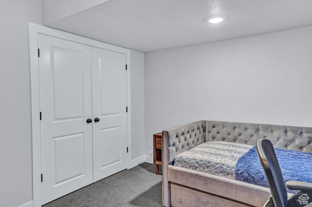 Bedroom featuring dark carpet and a closet