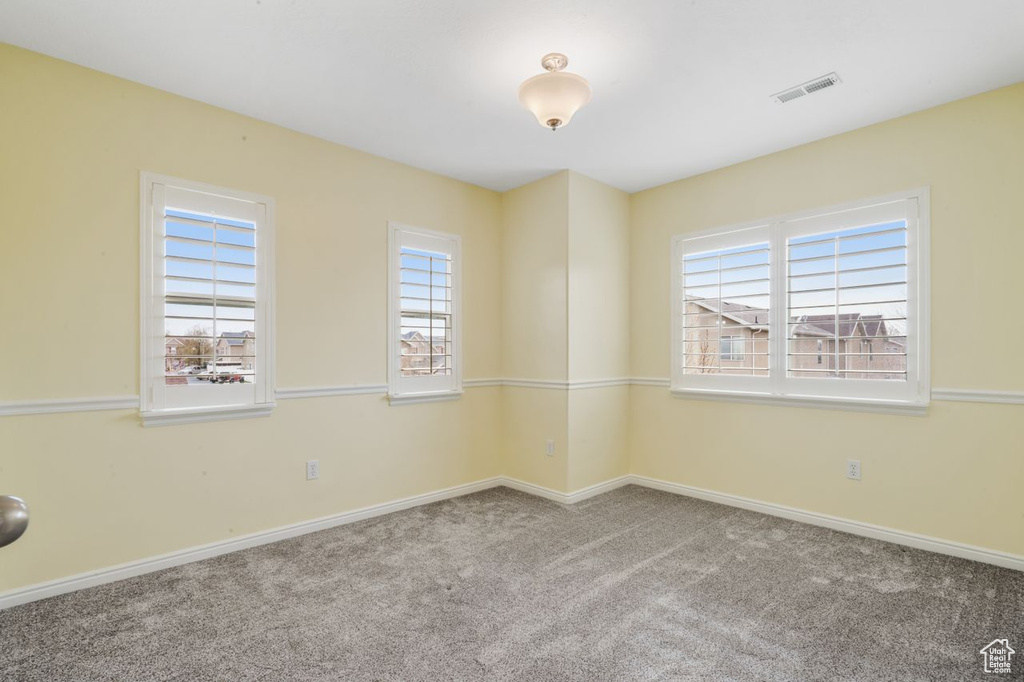 Unfurnished room with carpet floors and a healthy amount of sunlight