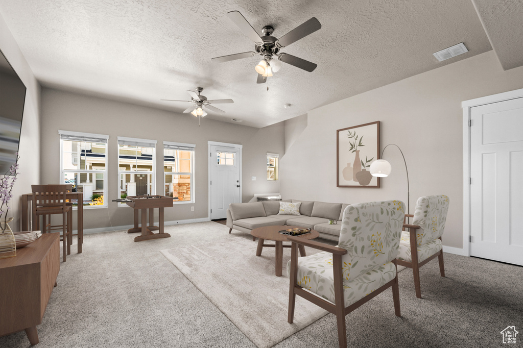 Living room with light carpet, ceiling fan, and a textured ceiling