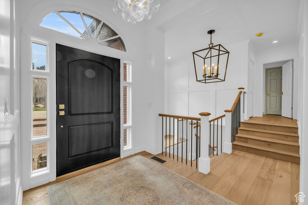 Entryway with light hardwood / wood-style flooring, a chandelier, and plenty of natural light