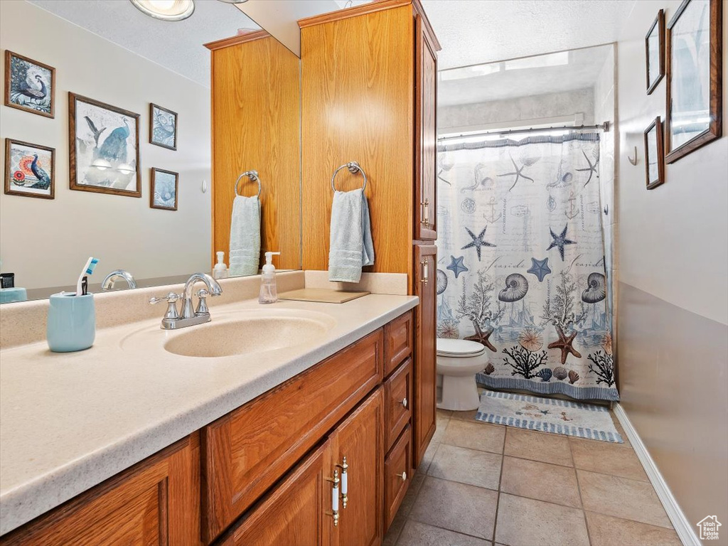 Bathroom featuring oversized vanity, toilet, and tile floors